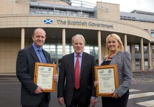 3 people holding their BREEAM certificates
